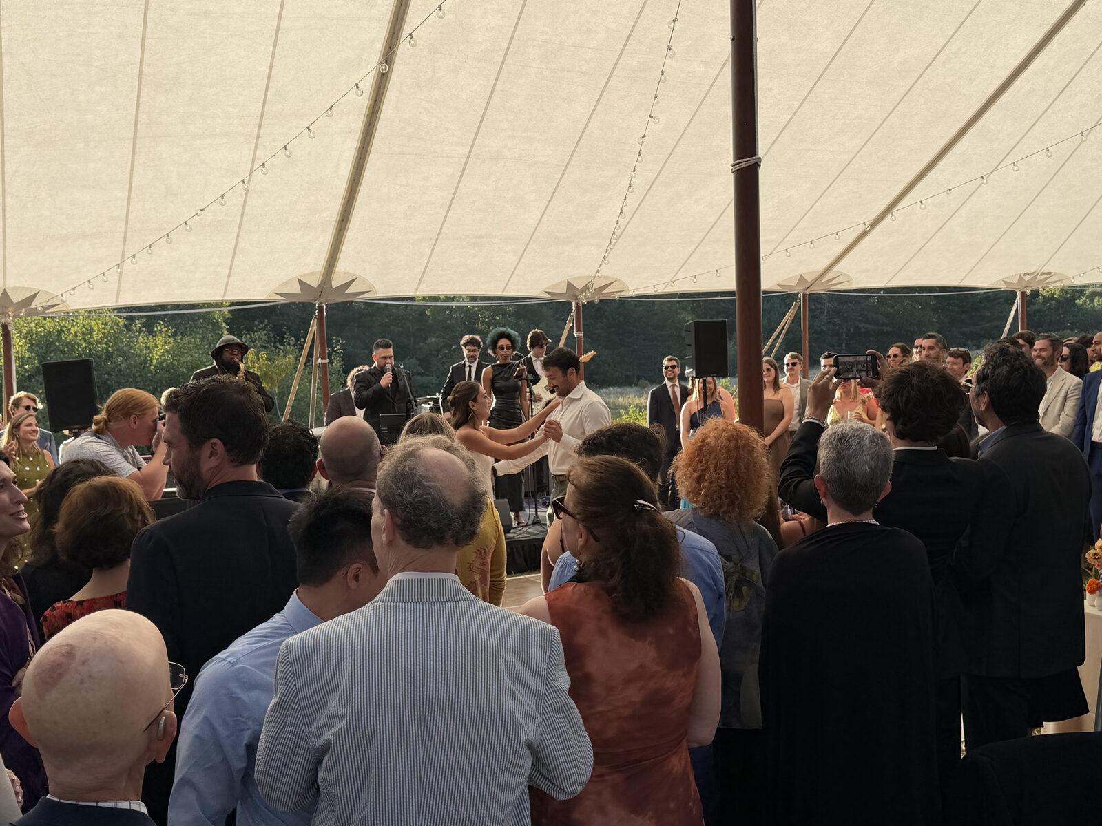 Guests dance under the sailcloth tent as the band plays