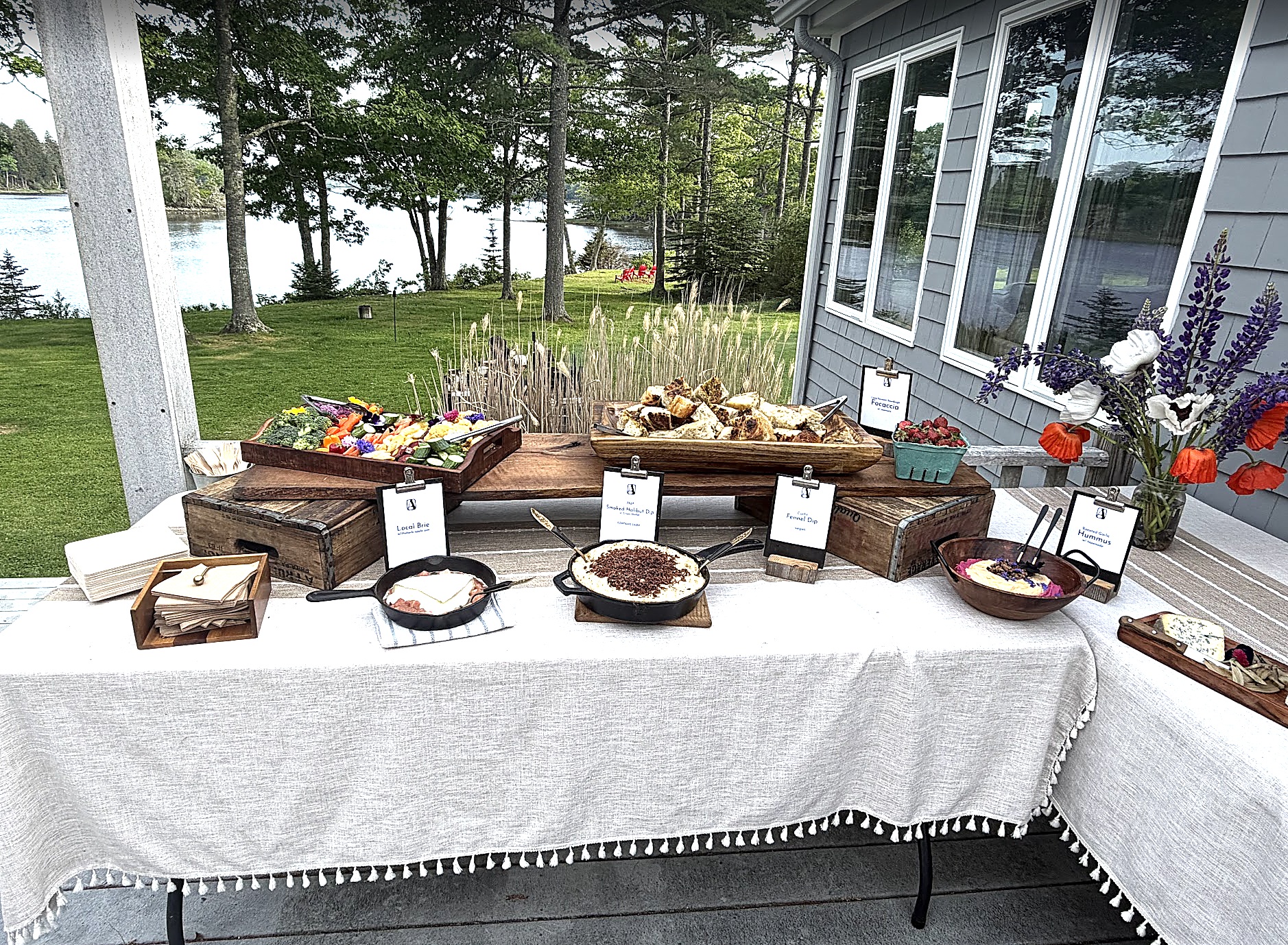 The estate house's back porch, set with a catering spread overlooking the harbor