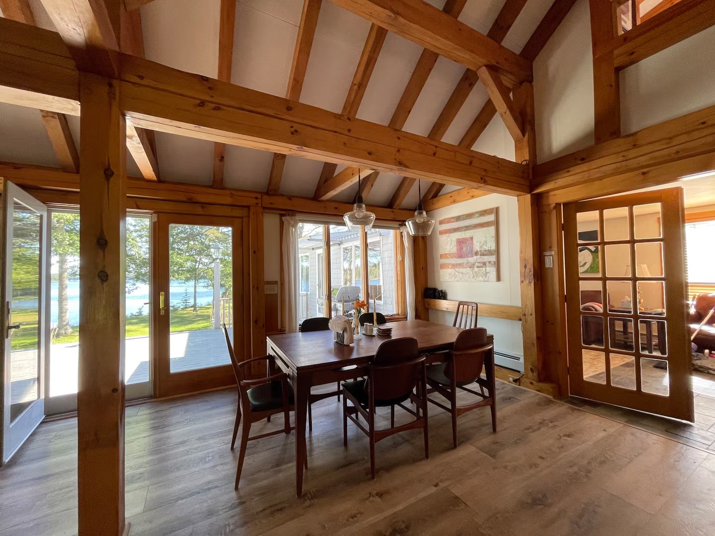 The dining room, timber-framed with French doors opening to a water view