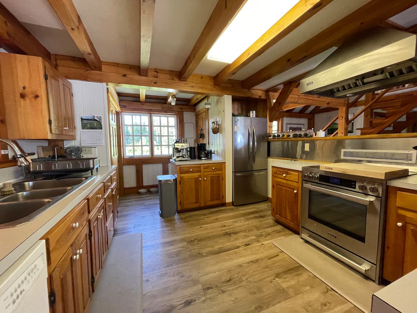 A second view of the kitchen, with a farmhouse table and view to the water