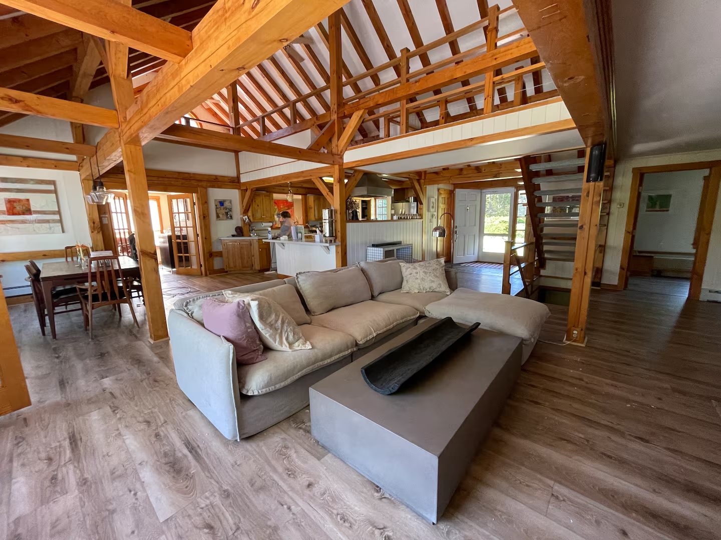 The open-plan living area with a loft overlook and kitchen beyond