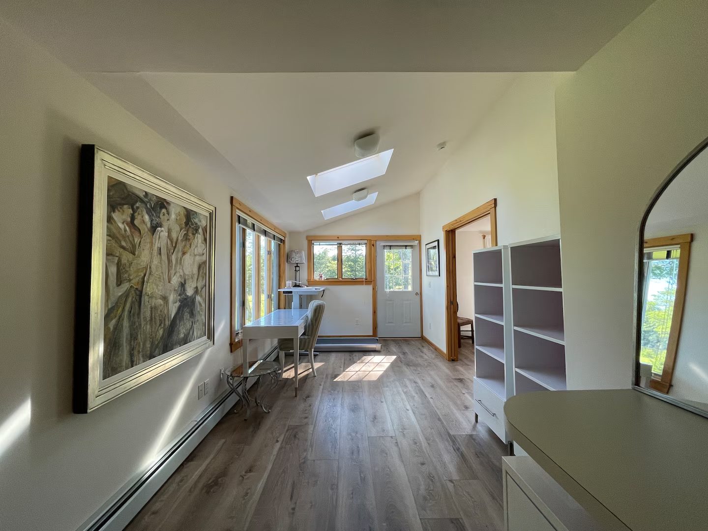 A skylit study nook with a large original painting on the wall